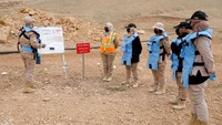Anggota tim wanita Irak dari Yayasan Swiss untuk Pekerjaan Ranjau memberikan arahan kepada timnya, sebelum mencari ranjau yang ditanam oleh militan ISIS, di pinggiran Mosul, Irak, Minggu, (27/3/2022).