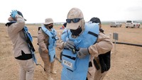 Para pemburu ranjau memakai pakaian keselamatan sebelum bekerja di ladang ranjau.