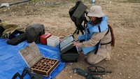 Seorang pemburu ranjau mengenakan peralatan keselamatan, bersiap untuk bekerja di ladang ranjau.