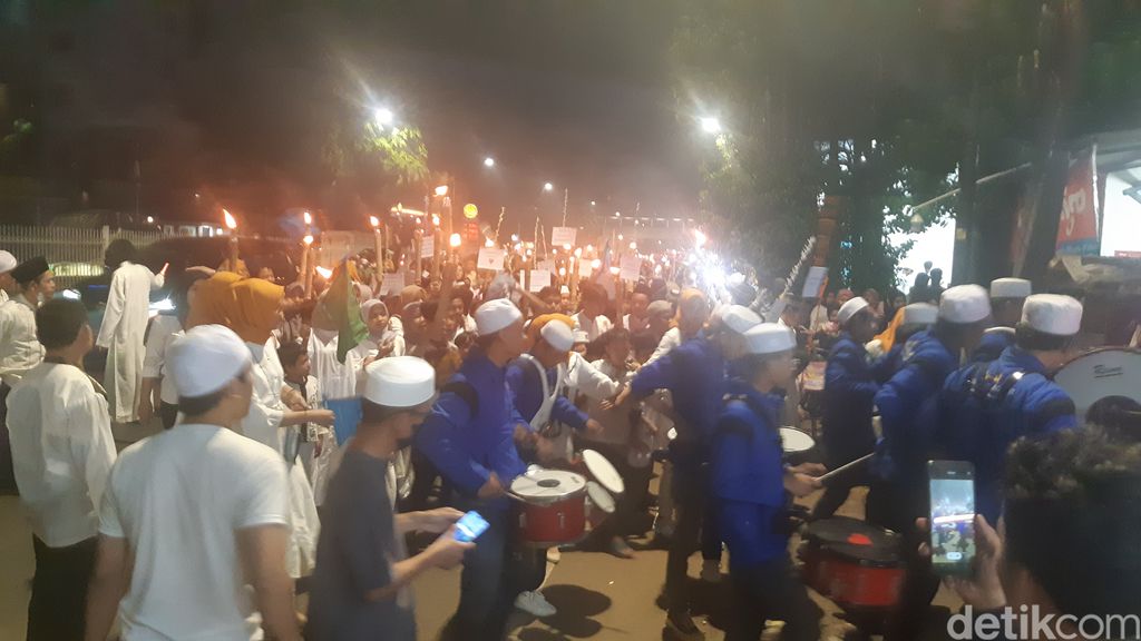 Pawai obor lewat Jl Mampang Prapatan Raya dan belok ke Jl Mampang Prapatan V, 29 Maret 2022, 20.00 WIB. (Danu Damarjati/detikcom)