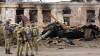 Tentara Ukraina berdiri di depan bangkai tank Rusia yang hancur dalam pertempuran di Trostsyanets.  (AP Photo/Efrem Lukatsky)