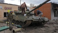 Tentara Ukraina berdiri di atas  tank Rusia yang hancur dalam pertempuran di Trostsyanets. (AP Photo/Efrem Lukatsky)