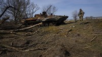 Tentara Ukraina berdiri di depan tank Rusia yang hancur dalam pertempuran di Brovary, Ukraina, Selasa (28/3/2022).  (AP Photo/Rodrigo Abd)