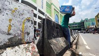 Sejumlah warga menerobos beton tinggi pembatas jalan di kawasan Tanah Abang, Jakarta, Selasa (29/03/2022).