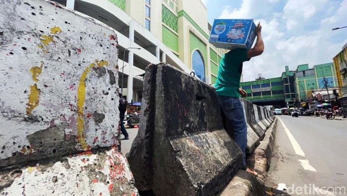 Sejumlah warga menerobos pembatas jalan di kawasan Tanah Abang, Jakarta, Selasa (29/3). Aksi tidak tertib ini dilakukan saat menyeberang jalan.