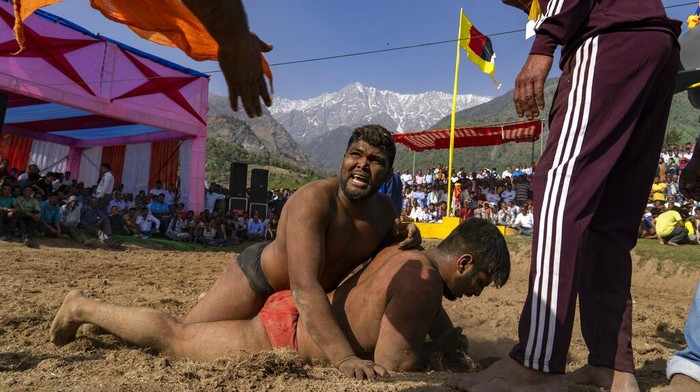 Wrestlers compete for a cash prize at a local fair in Dharmsala, India, Tuesday, March 29, 2022. These local fairs, once an annual feature, are slowly returning after being cancelled during the COVID-19 pandemic. (AP Photo/Ashwini Bhatia)