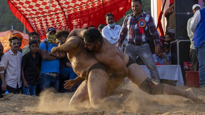 Wrestlers compete for a cash prize at a local fair in Dharmsala, India, Tuesday, March 29, 2022. These local fairs, once an annual feature, are slowly returning after being cancelled during the COVID-19 pandemic. (AP Photo/Ashwini Bhatia)