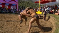 Para pegulat bersaing di area tarung di Dharamshala, India, Selasa (29/3/2022) waktu setempat.  Dharamsala terletak 500 km sebelah utara Ibu Kota New Delhi.