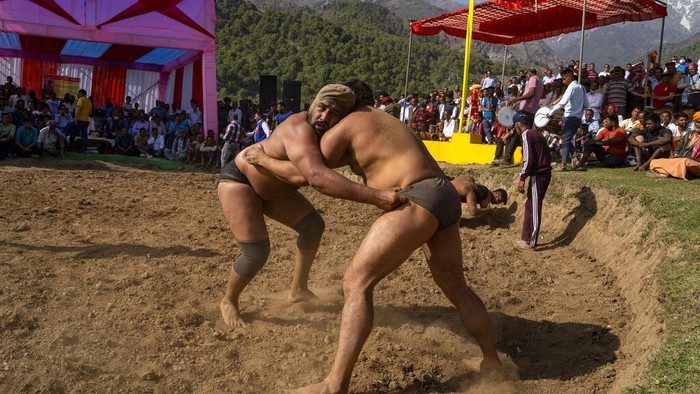 Adu Kuat Para Pegulat di India Wrestlers compete for a cash prize at a local fair in Dharmsala, India, Tuesday, March 29, 2022. These local fairs, once an annual feature, are slowly returning after being cancelled during the COVID-19 pandemic. (AP Photo/Ashwini Bhatia)