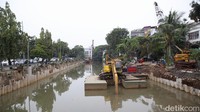 Pekerja dengan menggunakan alat berat memasang turap beton di pinggir Kali Ciliwung di kawasan Pasar Baru, Jakarta Pusat, Rabu (30/3/2022).   