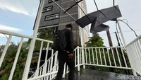 Seorang warga melintas di JPO yang kondisi atapnya rusak, Rabu (30/3/2022).