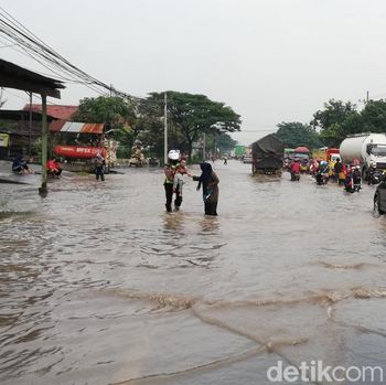 banjir di pantura pasuruan membuat polisi gendong balita