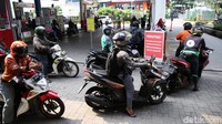 Pengendara sepeda motor mengantre untuk mengisi bahan bakar minyak di SPBU Kuningan, Jakarta Selatan.