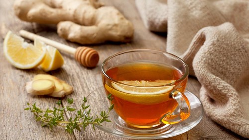 tea with ginger, lemon and thyme on old wooden background
