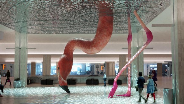 Patung flamingo menggambarkan hewan yang tengah mencelupkan kepalanya ke bawah permukaan air. Menarik ya? (Tampa International Airport)