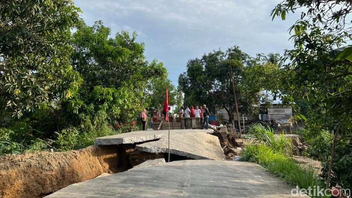 Jalan beton di Desa Kampale yang terbelah dan putus.