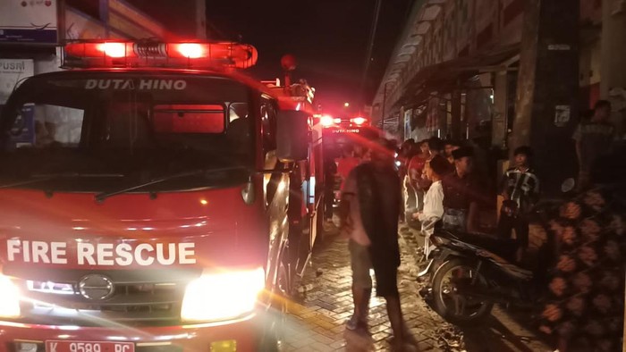 Petugas memadamkan api yang membakar ruko pakan ternak di Pasar Mayong, Jepara, Rabu (30/3/2022).