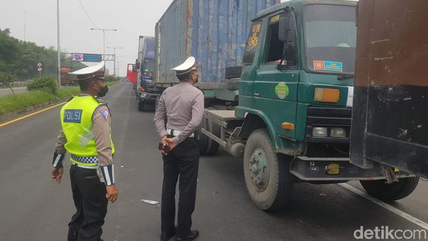Petugas mengatur lalu lintas mengurai kemacetan panjang di exit tol Manyar Gresik dengan ekor kemacetan 3 kilometer sampai JIIPE akibat Jembatan Balun di Lamongan yang ambles.