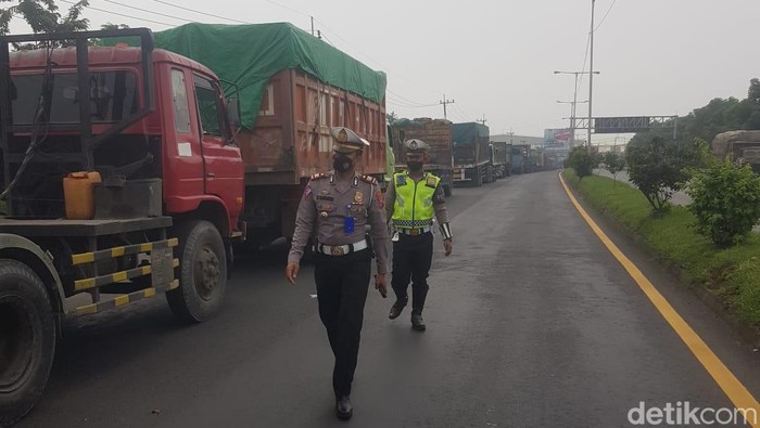 Petugas mengatur lalu lintas mengurai kemacetan panjang di exit tol Manyar Gresik dengan ekor kemacetan 3 kilometer sampai JIIPE akibat Jembatan Balun di Lamongan yang ambles.
