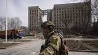 Seorang tentara Ukraina mengamankan daerah di area sekitar gedung pemerintah daerah Mykolaiv, Ukraina, yang hancur imbas serangan udara Rusia.  