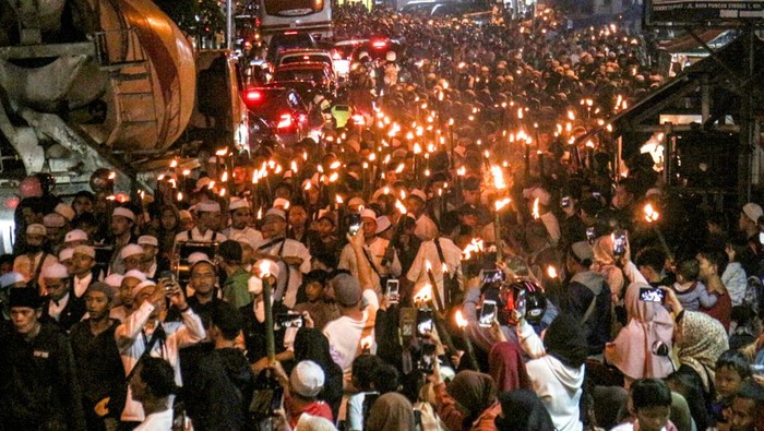 Sejumlah warga mengikuti pawai obor di Jalan Raya Puncak, Kabupaten Bogor, Jawa Barat, Rabu (30/3/2022). Kegiatan tersebut dalam rangka menyambut bulan suci Ramadhan 1443 Hijriah ANTARA FOTO/Yulius Satria Wijaya/aww.