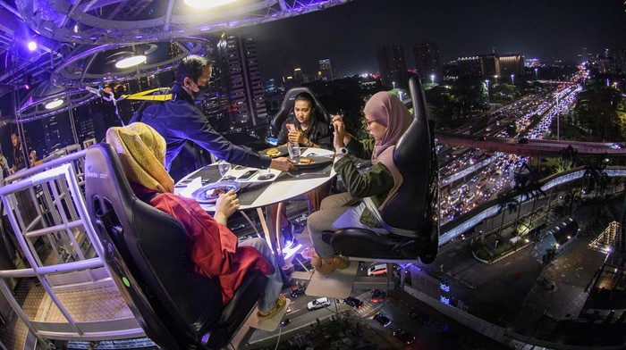Sensasi Menyantap Makanan di Ketinggian Jakarta, Berani Nggak? Pramusaji menghidangkan makanan dari ketinggian di Lounge in the Sky Indonesia di Jakarta, Selasa (29/3/2022). Destinasi wisata baru yang menawarkan sensasi menyantap hidangan dari ketinggian 50 meter dengan panorama Ibu Kota tersebut dapat dinikmati mulai dari harga Rp1,6 juta hingga Rp3,7 juta per orang. ANTARA FOTO/Sigid Kurniawan/foc.