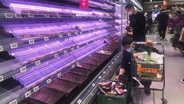 A delivery man selects items from partially empty shelves in Shanghai, China, Wednesday, March 30, 2022. As millions of Shanghai residents line up for coronavirus tests in the closed-down metropolis, authorities are promising tax cuts for shopkeepers and to keep its busy port functioning to limit disruptions to industry and trade. (AP Photo/Chen Si)