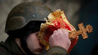 Pendeta militer Nikolay Medynsky memberkati seorang tentara Ukraina sebelum dia pergi berperang, saat serangan Rusia di Ukraina berlanjut, di Kyiv, Ukraina, (13/3/2022). (Thomas Peter/Reuters)