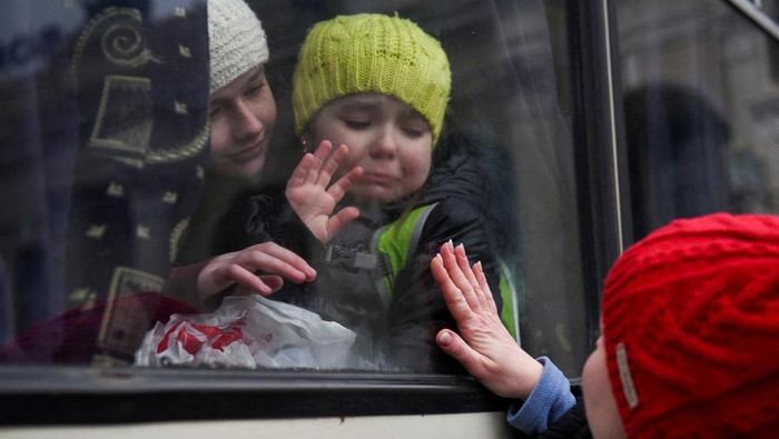 A woman cries as she comforts her son after learning she has to leave a bus which was reserved for the evacuation of orphans fleeing the ongoing Russian invasion outside the main train station in Lviv, Ukraine, March 5, 2022.   REUTERS/Kai Pfaffenbach