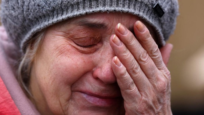 A woman cries as she comforts her son after learning she has to leave a bus which was reserved for the evacuation of orphans fleeing the ongoing Russian invasion outside the main train station in Lviv, Ukraine, March 5, 2022.   REUTERS/Kai Pfaffenbach