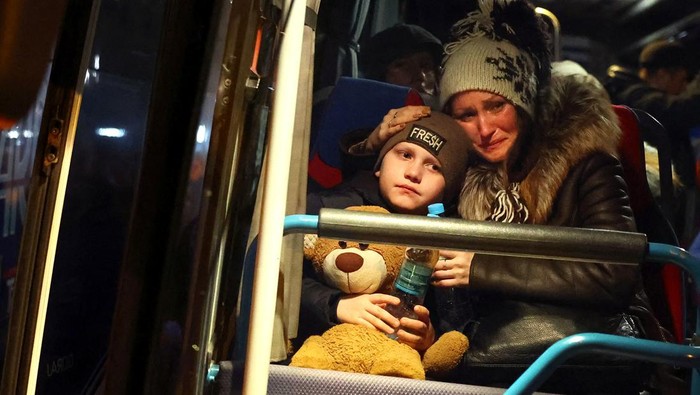 A woman cries as she comforts her son after learning she has to leave a bus which was reserved for the evacuation of orphans fleeing the ongoing Russian invasion outside the main train station in Lviv, Ukraine, March 5, 2022.   REUTERS/Kai Pfaffenbach