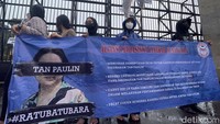 Dalam aksinya mereka membawa poster bergambar Tan Paulin.