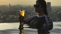 Santai sambil berenang, Dewi Perssik menikmati segelas minuman dingin. Meskipun foto ini hanya berbentuk siluet tetapi terlihat seksi. Foto: instagram @dewiperssikreal
