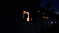 Seorang pria melihat keluar dari jendela di tengah pemadaman listrik yang berlangsung di Ibu Kota Kolombo, Sri Lanka, Rabu (30/3/2022).