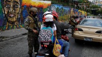 Seorang tentara menginterogasi seorang pria di sebuah pos pemeriksaan di lingkungan 22 de Abril di Soyapango, El Salvador, (29/3/2022).