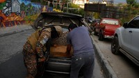 Seorang tentara menggeledah sebuah mobil di sebuah pos pemeriksaan di lingkungan 22 de Abril.