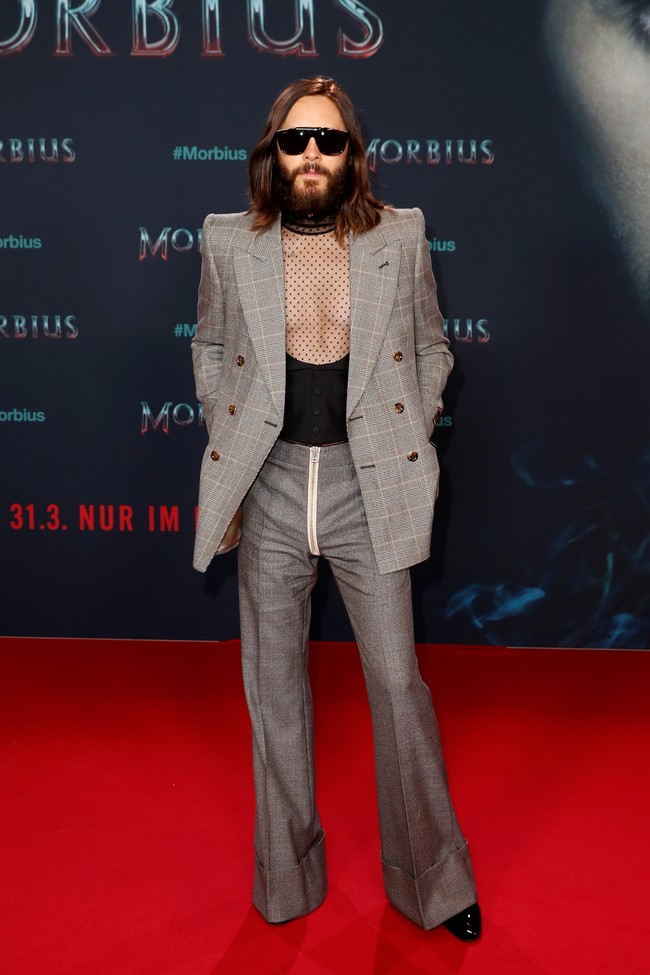 Pada malam harinya untuk karpet merah acara screening, Jared Leto bersolek dengan setelan yang terdiri dari jas motif kotak dan celana berpotongan cut-bray yang melebar di bagian bawah. Di balik blazer, terdapat dalam berbahan transparan sehingga menciptakan sentuhan feminin. (Foto: Getty Images for Sony Pictures/Gerald Matzka)