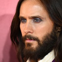 Meski busananya lebih kalem dari biasanya, Jared menghadirkan sentuhan eksentrik pada riasan wajahnya. Matanya dihiasi eye shadow ungu berefek shimmering yang mengilap. (Foto: Gareth Cattermole/Getty Images)