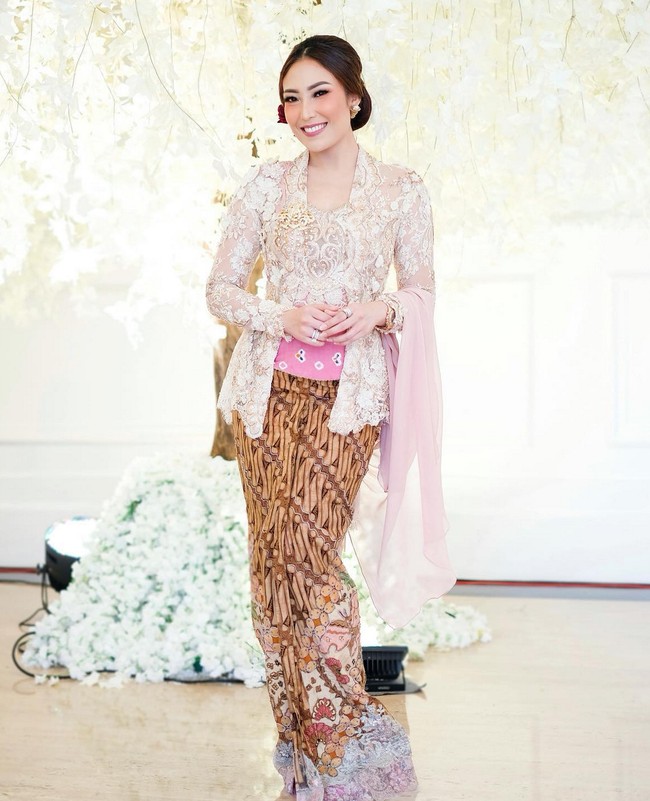 Ayu Dewi tampil cantik memakai kebaya bernuansa beige yang dipadu kain batik motif parang. Stagen motif jumputan berwarna pink menambah kesan cerah dan lebih girlie. Foto: Instagram