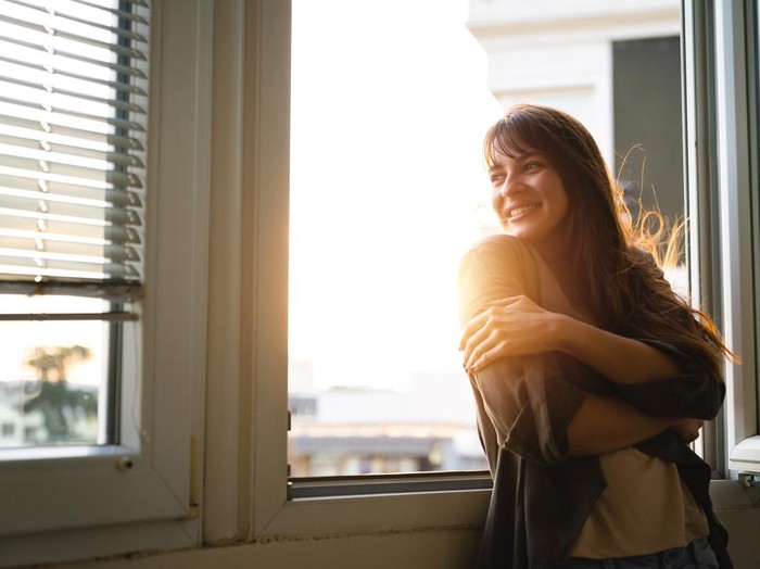 kepribadian wanita Beautiful young woman looking through the window while enjoying fresh air