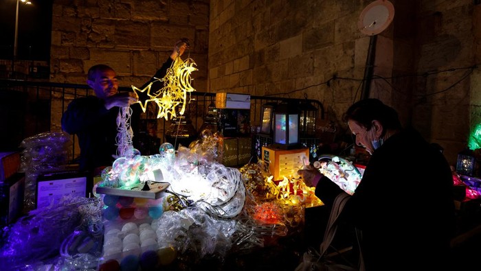 Kota Tua Yerusalem Bersolek Sambut Bulan Ramadan A man hangs decorations ahead of the holy month of Ramadan in Jerusalem's Old City, March 29, 2022. Picture taken March 29, 2022. REUTERS/Ammar Awad