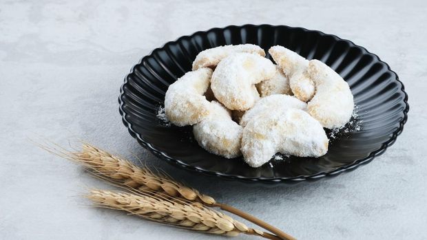 Kue Putri Salju, popular cookies for Eid celebrations in Indonesia. Served in small plate in grey background. Selective focus.
