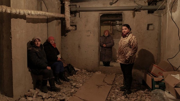 A woman and her daughter, who have been in hiding from bombardment since the beginning of the war, sit in the basement of an apartment building that serves as their bomb shelter in a neighbourhood that is left without water, gas and heating after of intensive shelling, as Russia's attack on Ukraine continues, in Kharkiv, Ukraine, March 28, 2022.  REUTERS/Thomas Peter