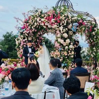 Son Ye Jin tersenyum manis saat Hyun Bin memasangkan cincin di jari manisnya. Meskipun hanya terlihat dari belakang, sang aktris terlihat anggun dalam balutan gaun Brunella rancangan desainer Mira Zwillinger. Foto: dok. Instagram @crashlandingonyou