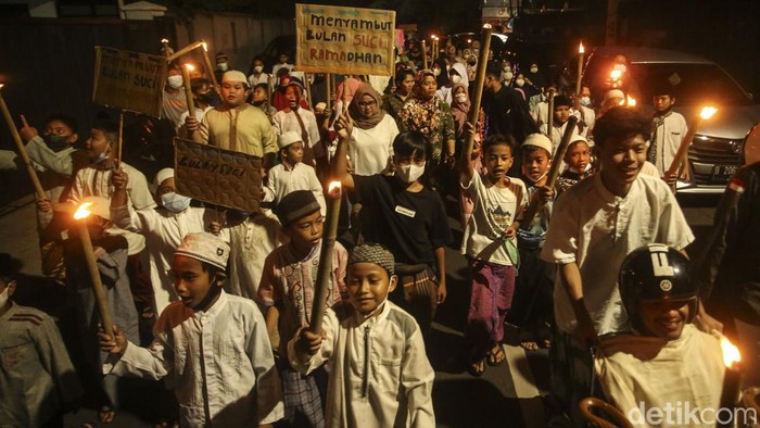 Sejumlah warga berjalan dengan membawa obor di kawasan Menteng, Jakarta Pusat, Kamis (31/3/2022). Pawai obor tersebut digelar guna menyambut datangnya bulan suci ramadan.