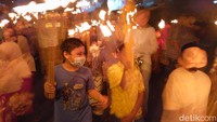 Mereka tampak riang gembira mengikuti pawai obor.