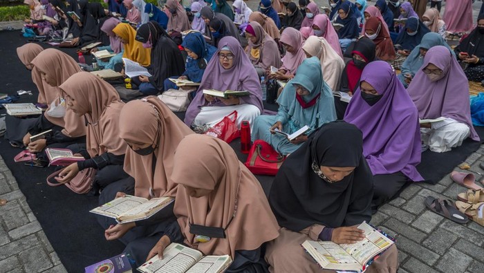 Sejumlah muslimah membaca Al Quran bersama-sama pada 