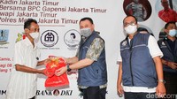 Wakil Walikota Jakarta Timur Hendra Hidayat didampingi Ketua Kamar Dagang Indonesia Jakarta Timur Anta Ginting memberikan minyak goreng gratis kepada warga yang mengikuti vaksinasi booster.