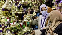 Seorang wanita memeriksa lentera Ramadan tradisional, yang disebut Fanous, di sebuah kios menjelang bulan suci Ramadan, di Kairo, Mesir, Kamis, (31/3/2022).