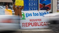Aktivis dari Partai Republik membawa spanduk di sebuah SPBU di Garden Grove, California, Selasa (29/3/2022). Tampak aktivis membawa poster bertuliskan Bunyikan Klakson untuk Harga BBM Murah !!